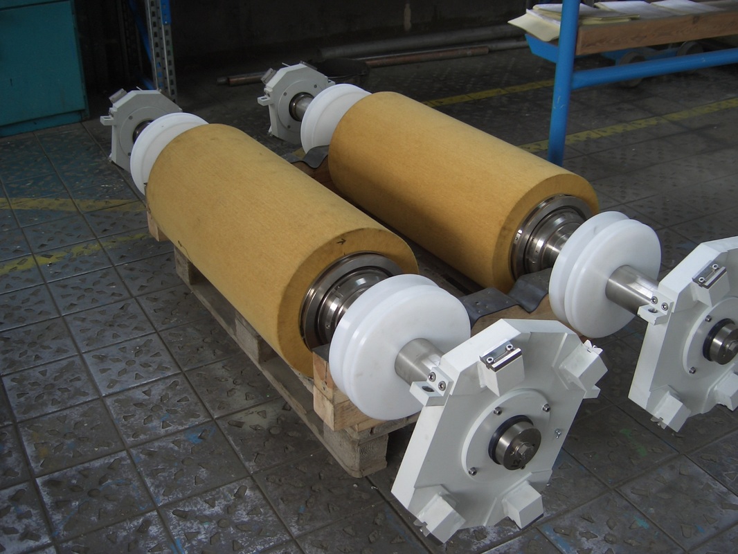 Picture of abrasive non-woven wide face scrubber brush on shafts and bearing blocks ready to be loaded in wide metal strip processing machine